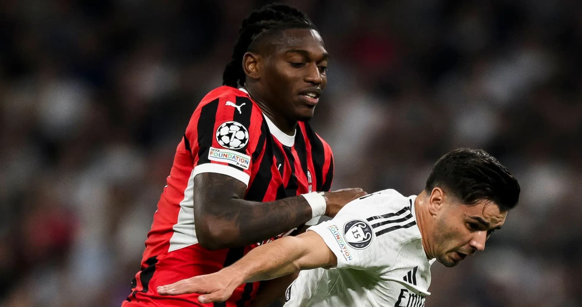 Jugador de AC Milan empujando a oponente del Real Madrid