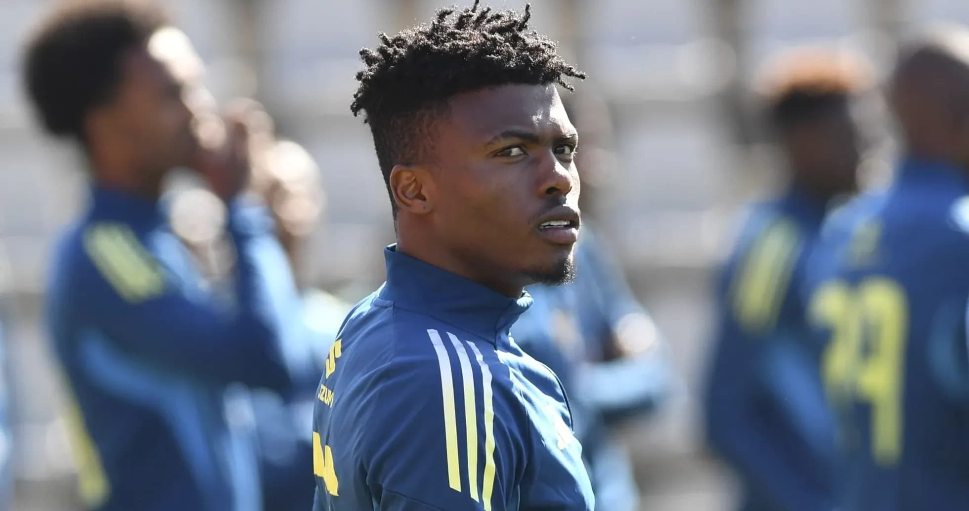 Jugador entrenando en el campo con compañeros