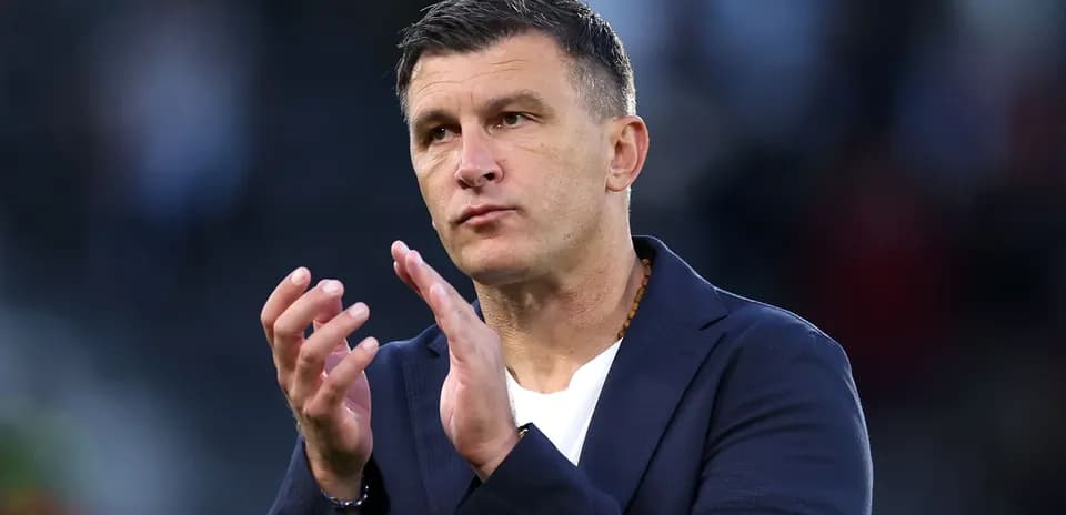 Entrenador aplaudiendo en la banda del campo