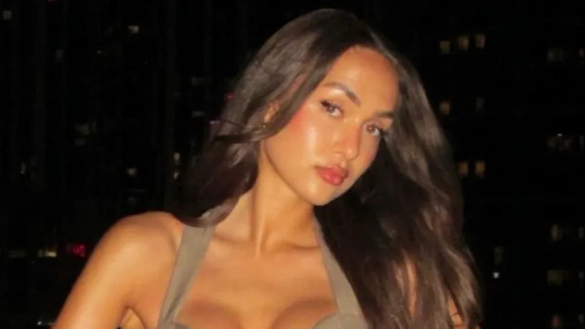 Mujer posando con fondo de edificios iluminados