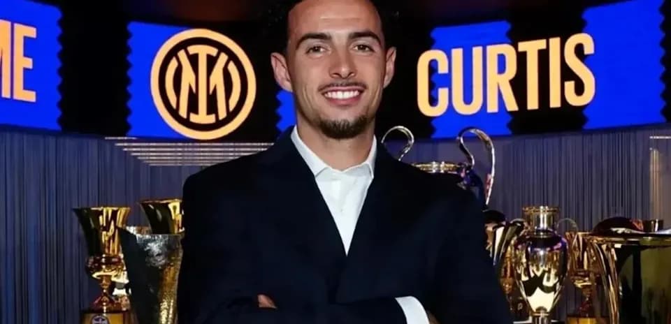 Persona sonriente en evento con trofeos de fútbol