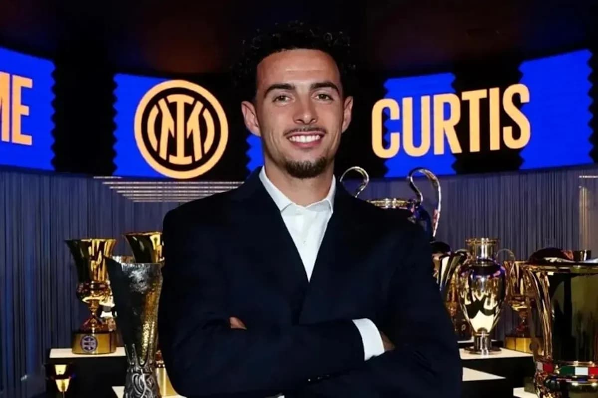 Persona sonriente en evento con trofeos de fútbol