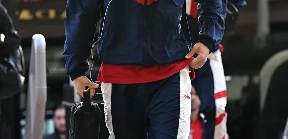 Jugador llegando con traje de entrenamiento y maletín