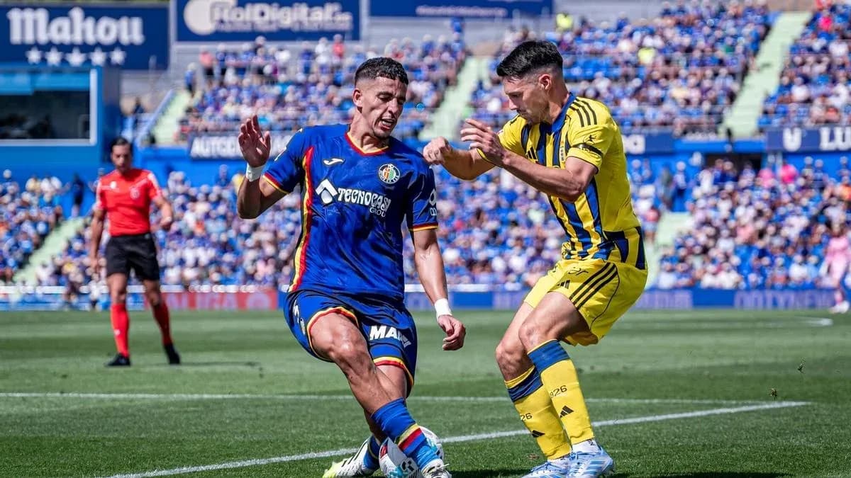 Jugador de Getafe tratando de evitar falta