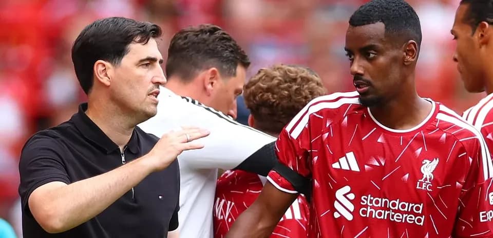 Entrenador hablando con jugador durante calentamiento