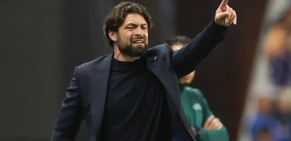 Entrenador dirigiendo instrucciones desde la banda