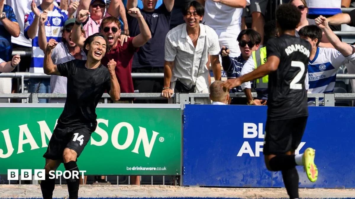 Jugador celebrando gol con aficionados en estadio