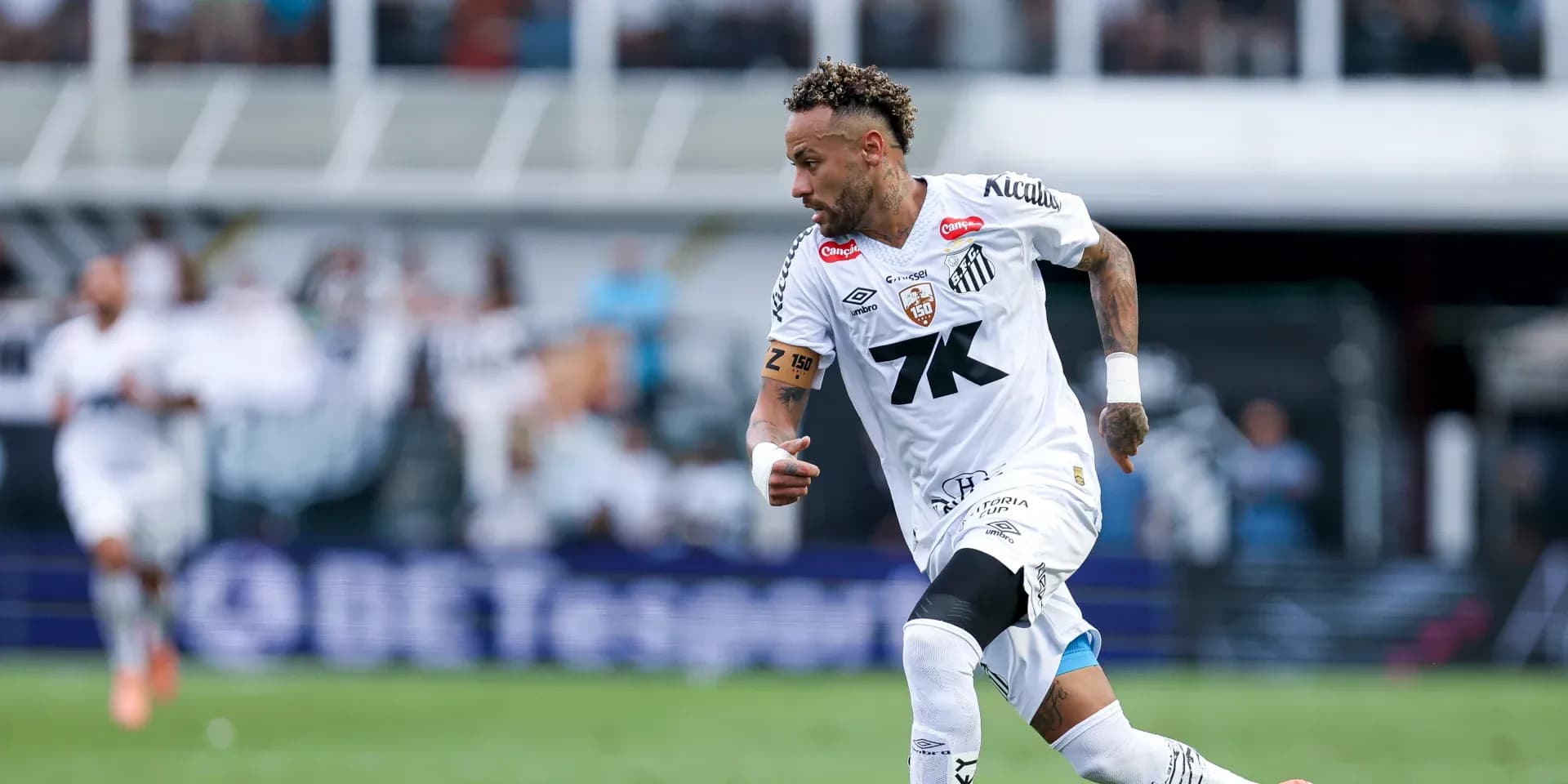 Jugador corriendo con balón en el campo de fútbol