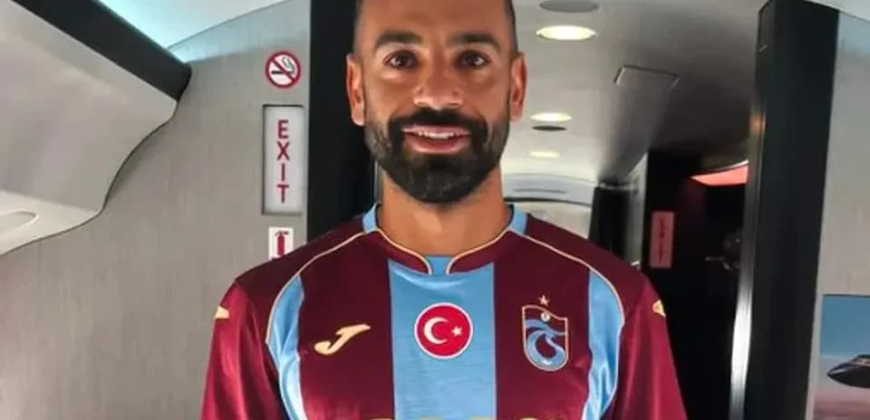 Jugador de fútbol con camiseta de Trabzonspor en avión