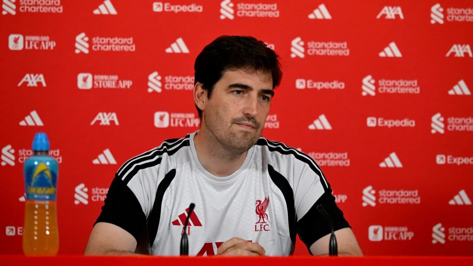 Entrenador en rueda de prensa con fondo rojo