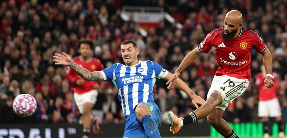 Jugador de Brighton intentando detener a un jugador de Manchester United