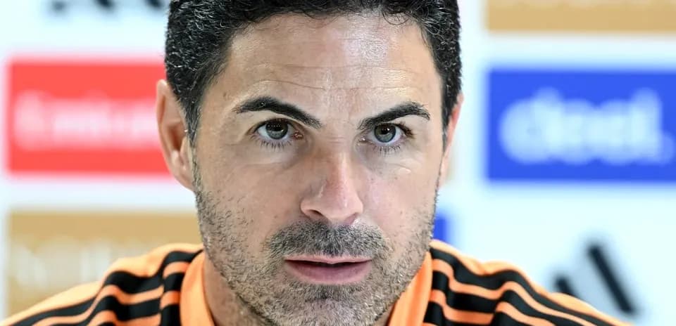 Entrenador en conferencia de prensa con camiseta naranja
