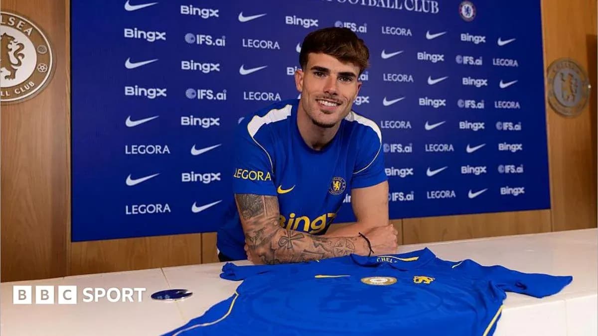 Jugador posando con camiseta de Chelsea en rueda de prensa