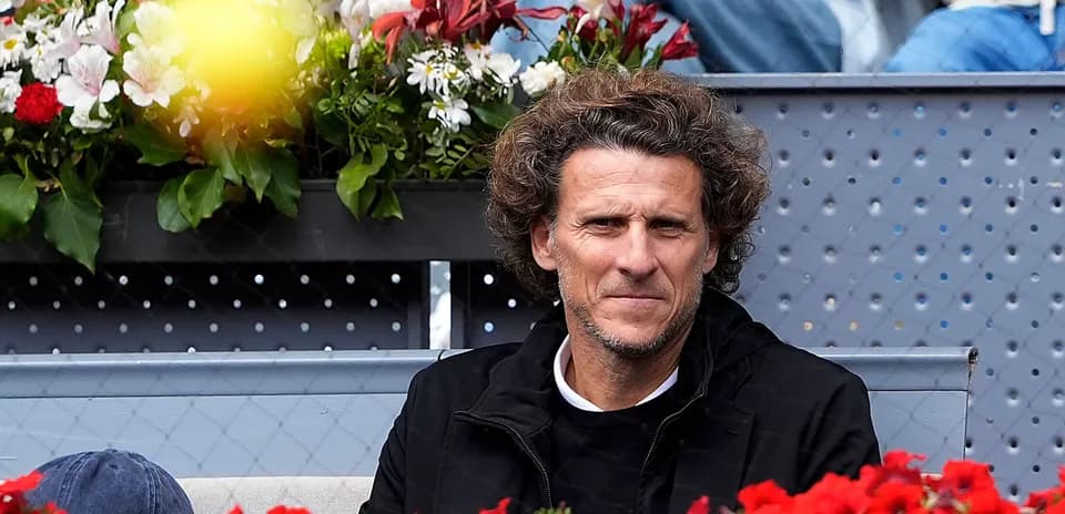 Hombre sentado en la grada rodeado de flores