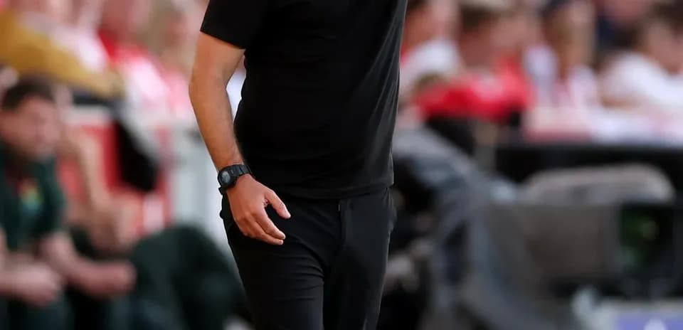 Entrenador dando instrucciones desde la línea de banda