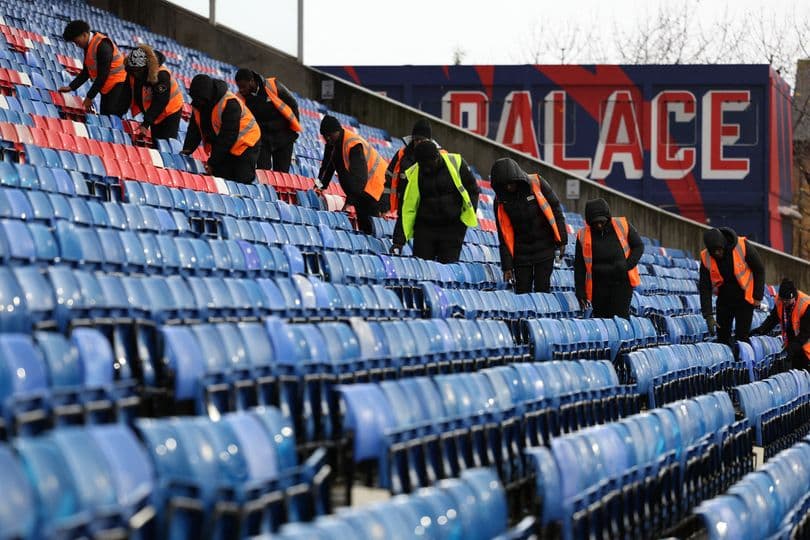 Trabajadores limpiando asientos en el estadio