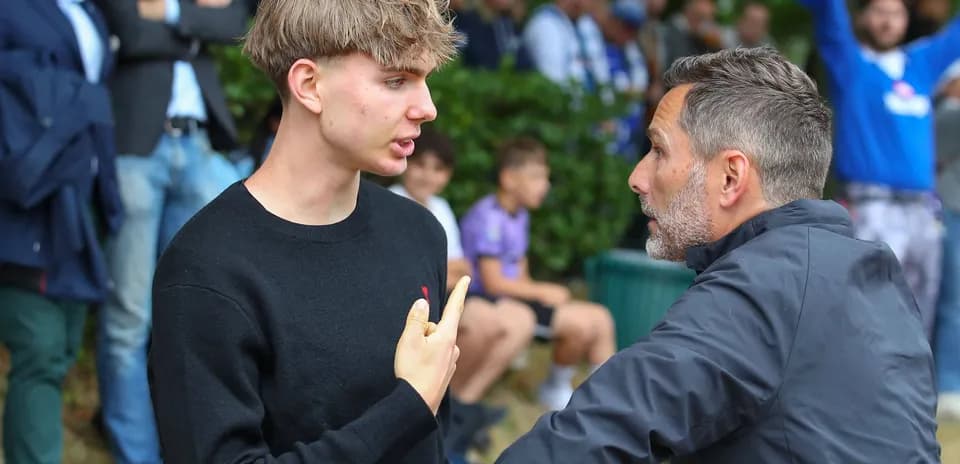 Joven discutiendo con un hombre mayor en evento deportivo