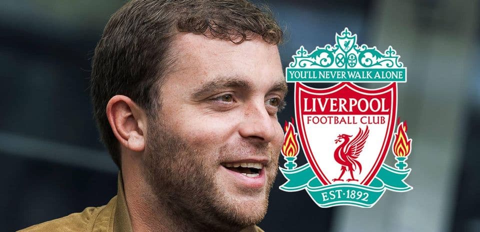 Hombre sonriendo con el escudo del Liverpool FC
