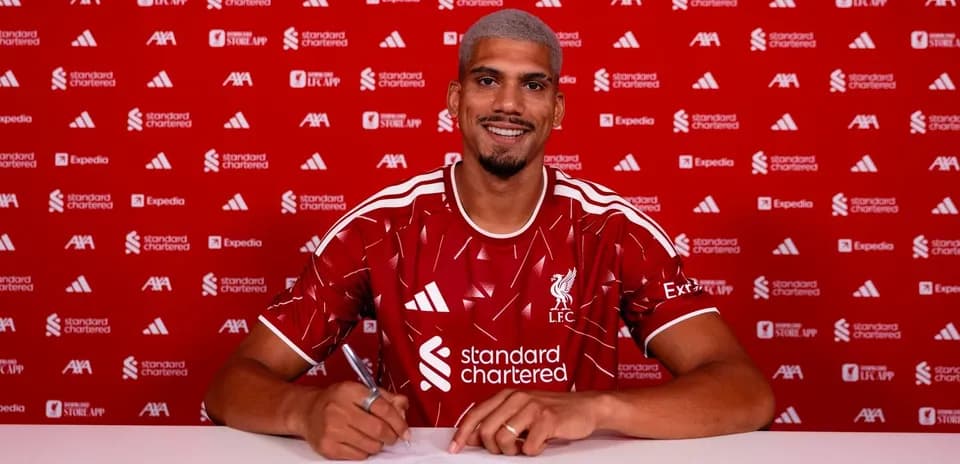 Jugador firmando contrato con camiseta de Liverpool