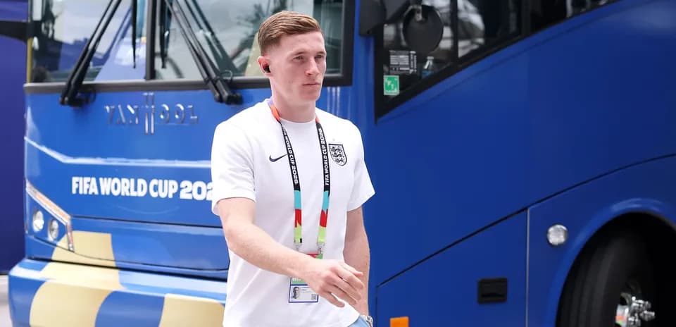 Jugador caminando junto a autobús de la Copa Mundial