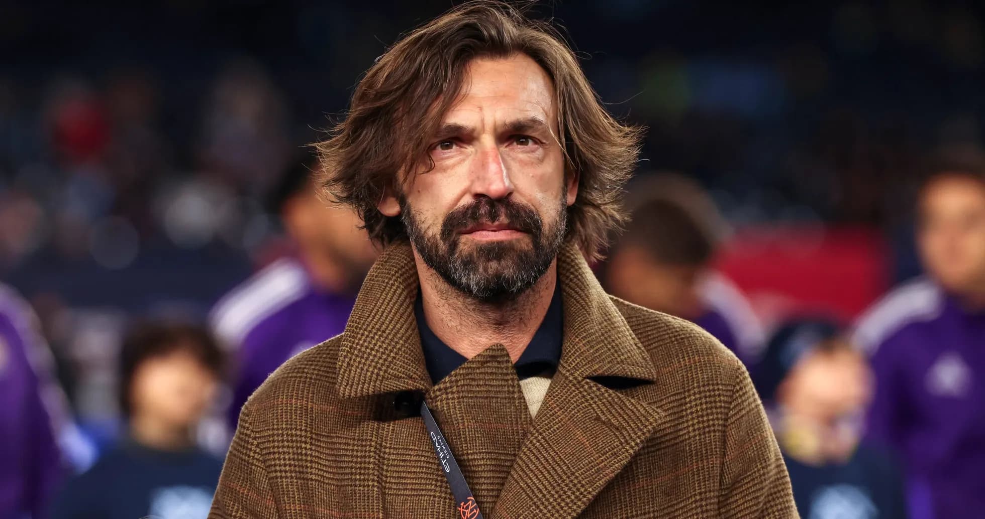 Hombre con abrigo en evento deportivo Hombre con abrigo en evento deportivo