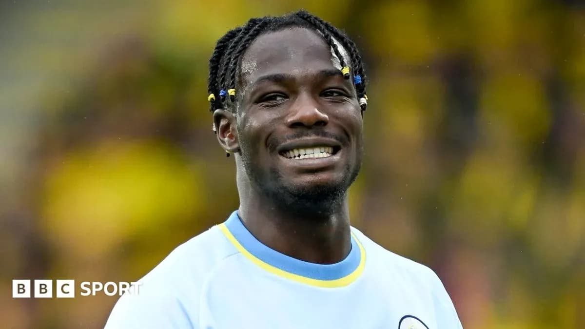 Jugador sonriendo con camiseta azul en el campo Jugador sonriendo con camiseta azul en el campo