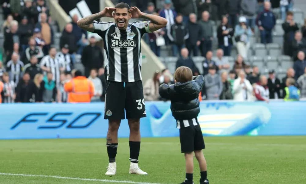 Jugador de Newcastle celebrando con un niño en el campo Jugador de Newcastle celebrando con un niño en el campo