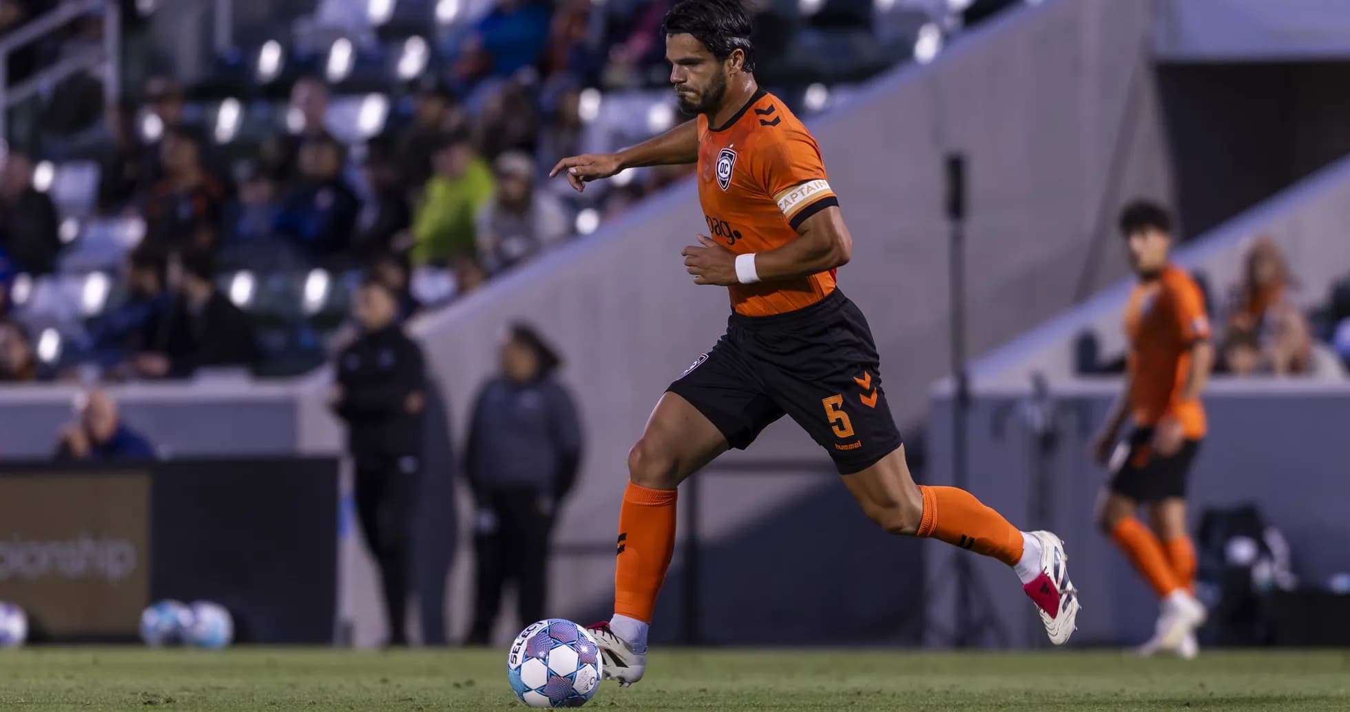 Jugador de Orange County SC corriendo con el balón Jugador de Orange County SC corriendo con el balón