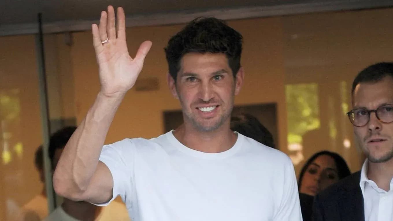 Jugador saludando mientras sale de edificio Jugador saludando mientras sale de edificio