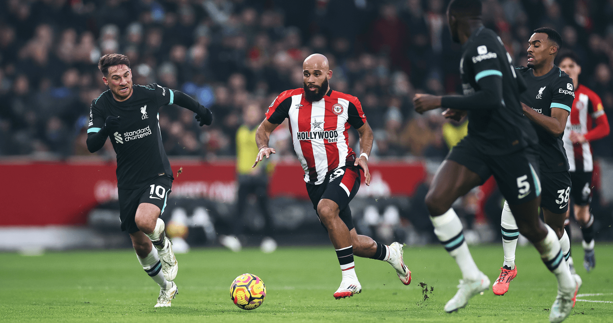 Jugador de Brentford driblando a jugadores de Liverpool Jugador de Brentford driblando a jugadores de Liverpool
