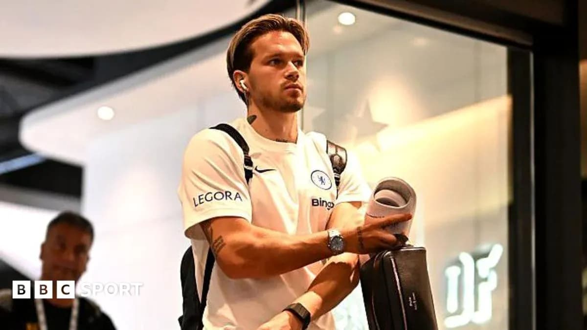 Jugador de Chelsea llegando con auriculares y maleta Jugador de Chelsea llegando con auriculares y maleta