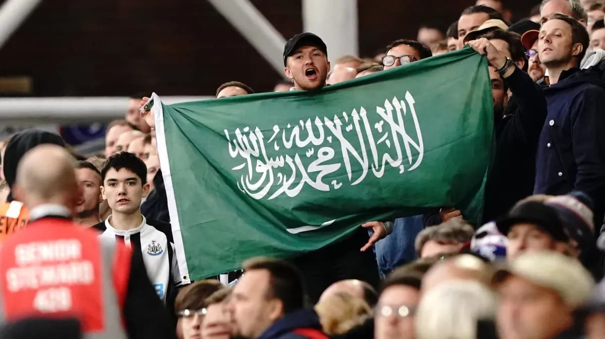Afan de pie sosteniendo una bandera de Arabia Saudita Afan de pie sosteniendo una bandera de Arabia Saudita