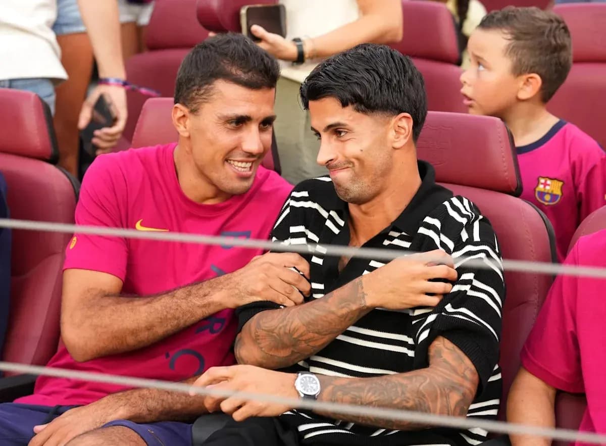 Dos jugadores sentados en un estadio durante evento Dos jugadores sentados en un estadio durante evento