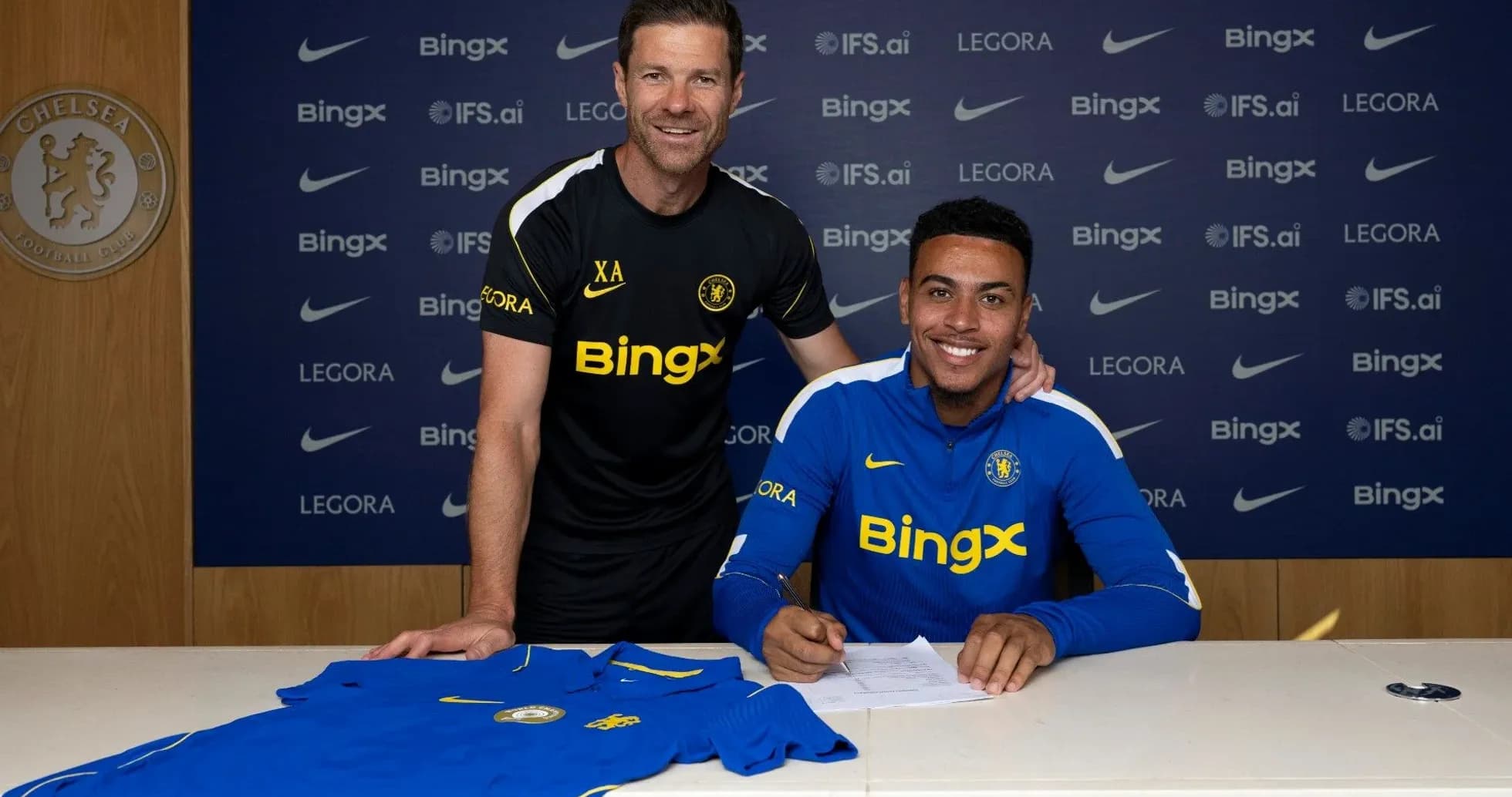 Jugador firmando contrato con entrenador en club Chelsea Jugador firmando contrato con entrenador en club Chelsea