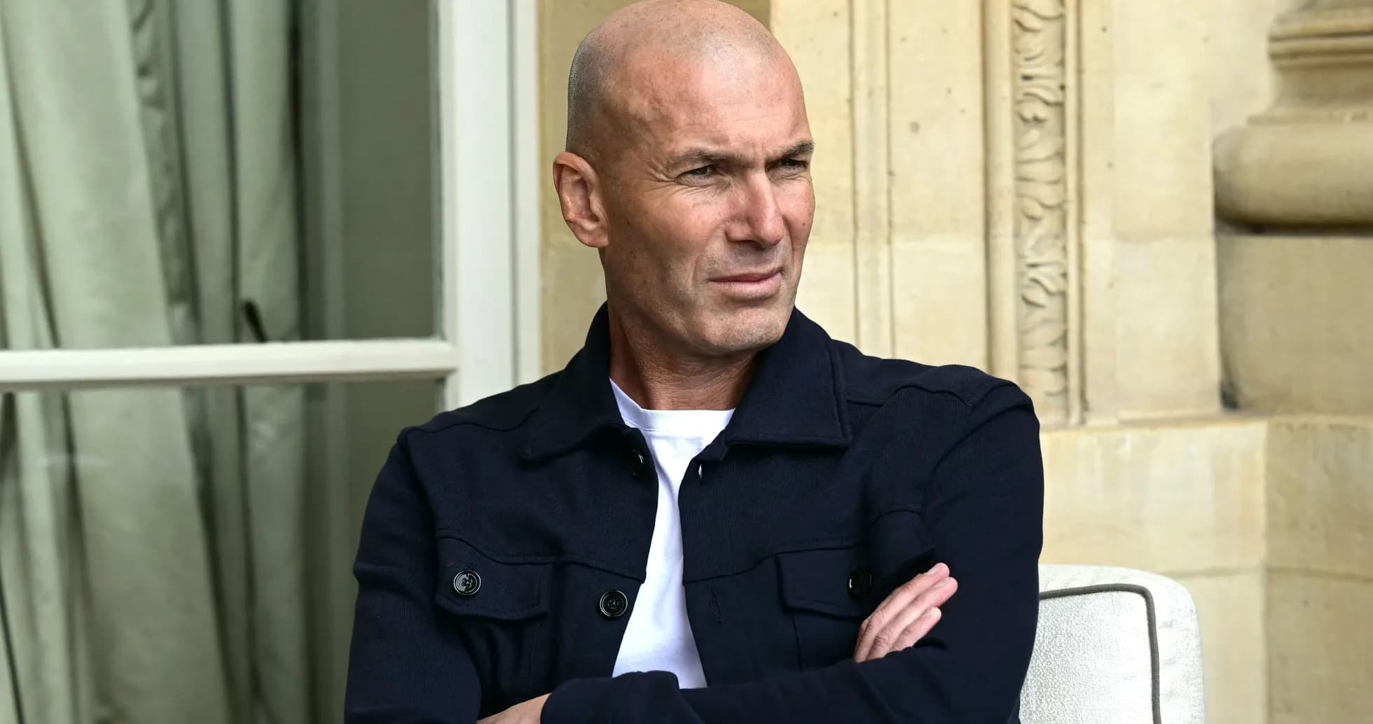 Hombre con chaqueta oscura sentado con los brazos cruzados Hombre con chaqueta oscura sentado con los brazos cruzados