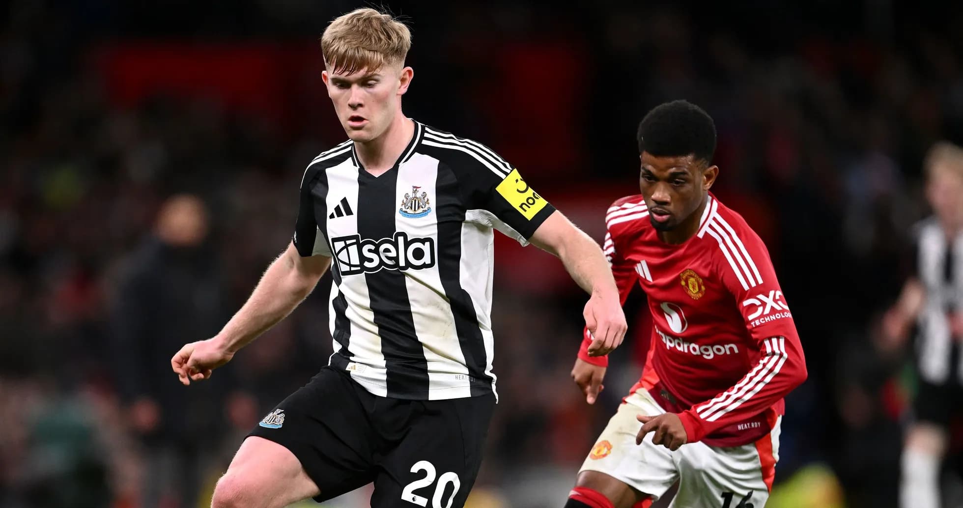 Jugador de Newcastle driblando ante oponente de Manchester Jugador de Newcastle driblando ante oponente de Manchester