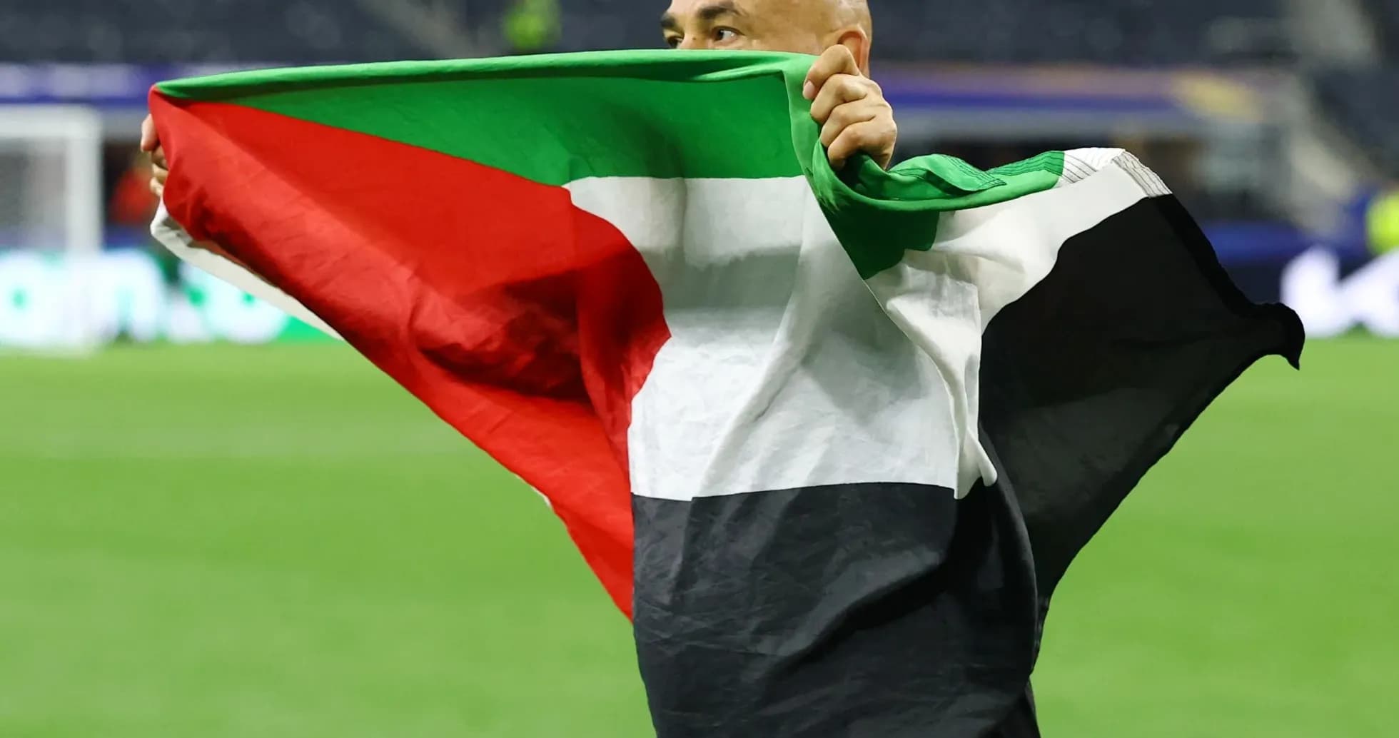 Hombre sosteniendo una bandera palestina en el campo Hombre sosteniendo una bandera palestina en el campo
