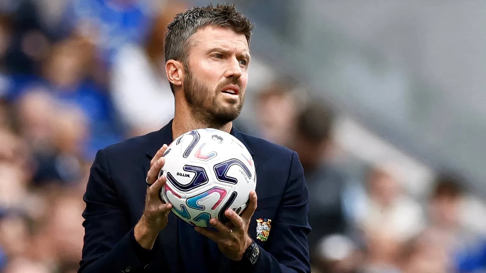 Entrenador sosteniendo un balón durante un partido Entrenador sosteniendo un balón durante un partido