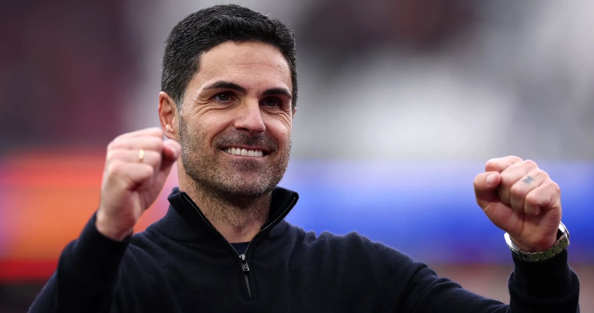 Entrenador sonriendo con puños en alto durante celebración Entrenador sonriendo con puños en alto durante celebración