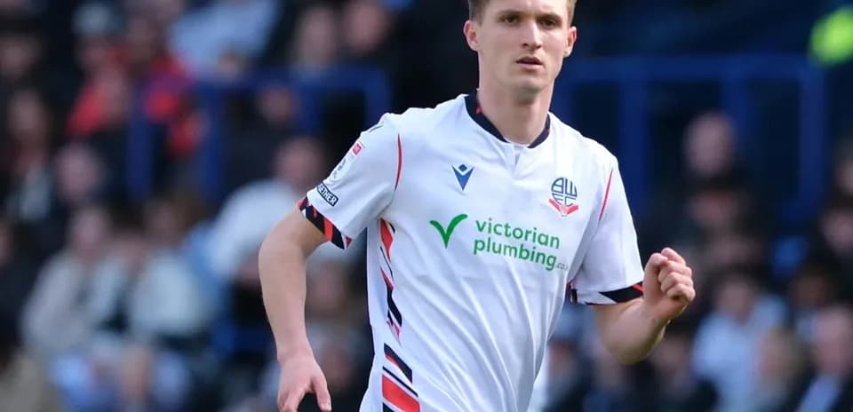 Jugador de Bolton Wanderers corriendo en el campo Jugador de Bolton Wanderers corriendo en el campo