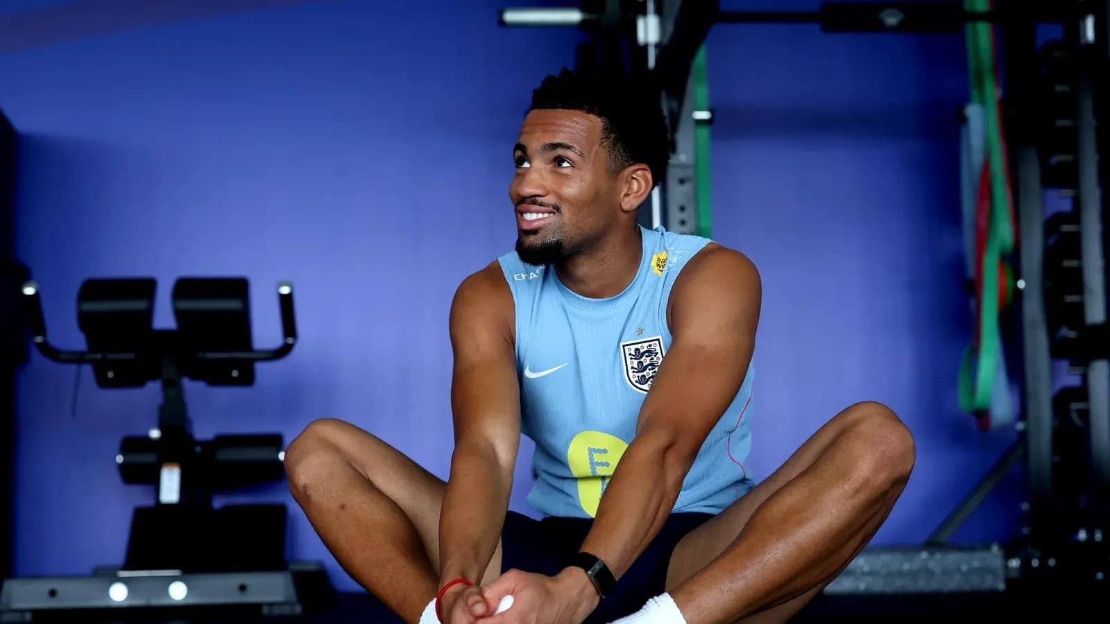 Jugador sentado estirando en gimnasio de entrenamiento Jugador sentado estirando en gimnasio de entrenamiento
