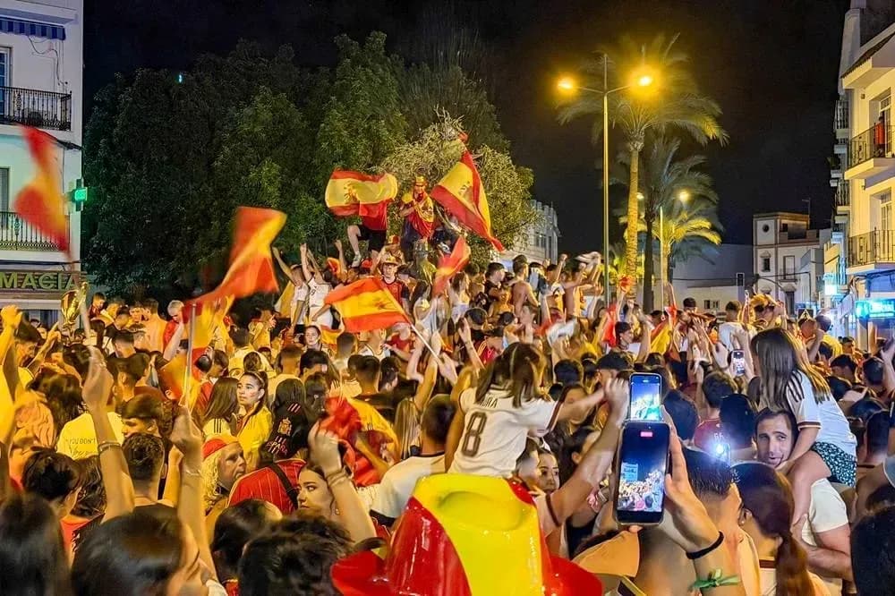 Celebration crowd waving Spanish flags at night Celebration crowd waving Spanish flags at night