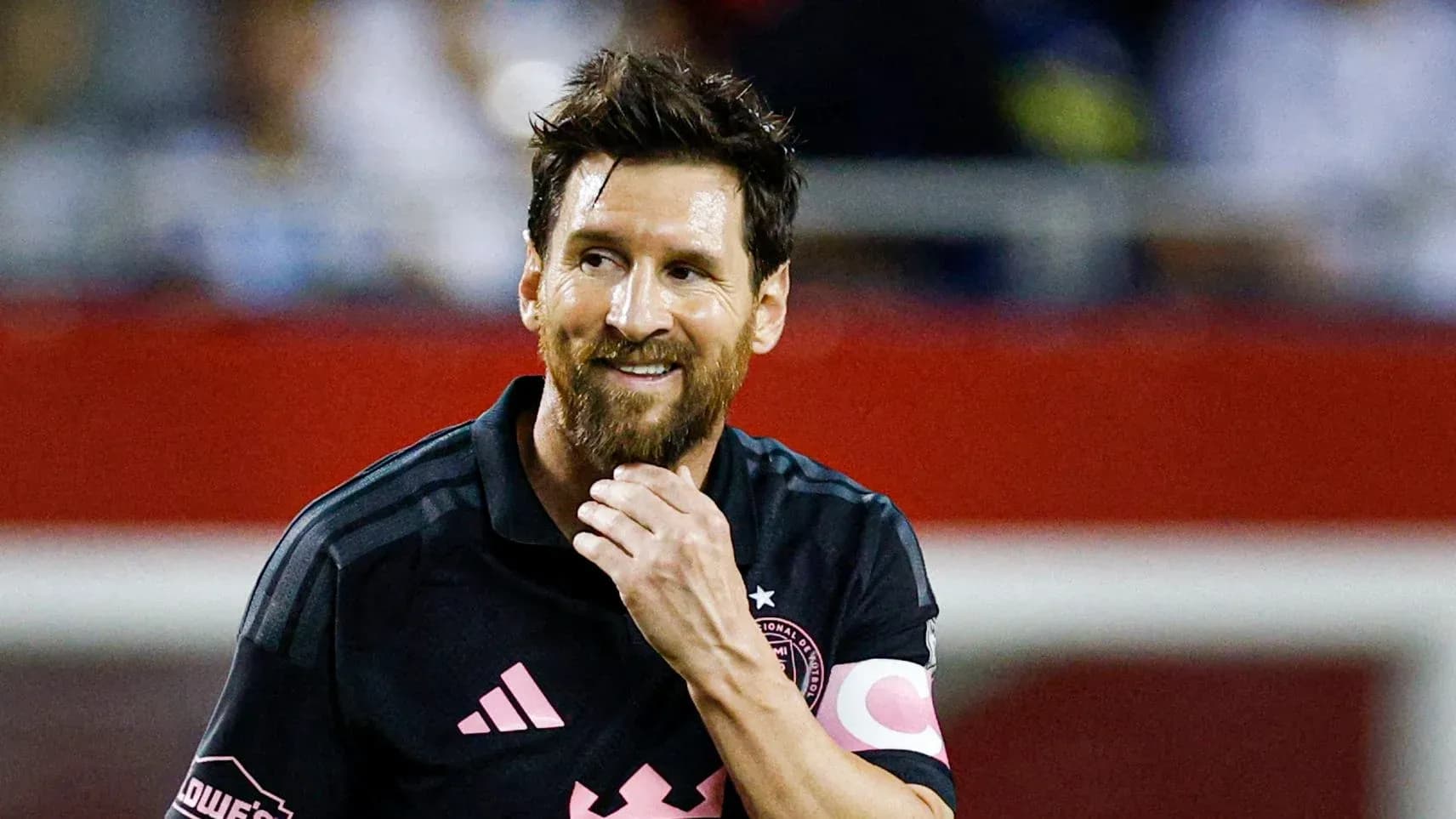 Jugador con camiseta negra sonriendo en el campo Jugador con camiseta negra sonriendo en el campo
