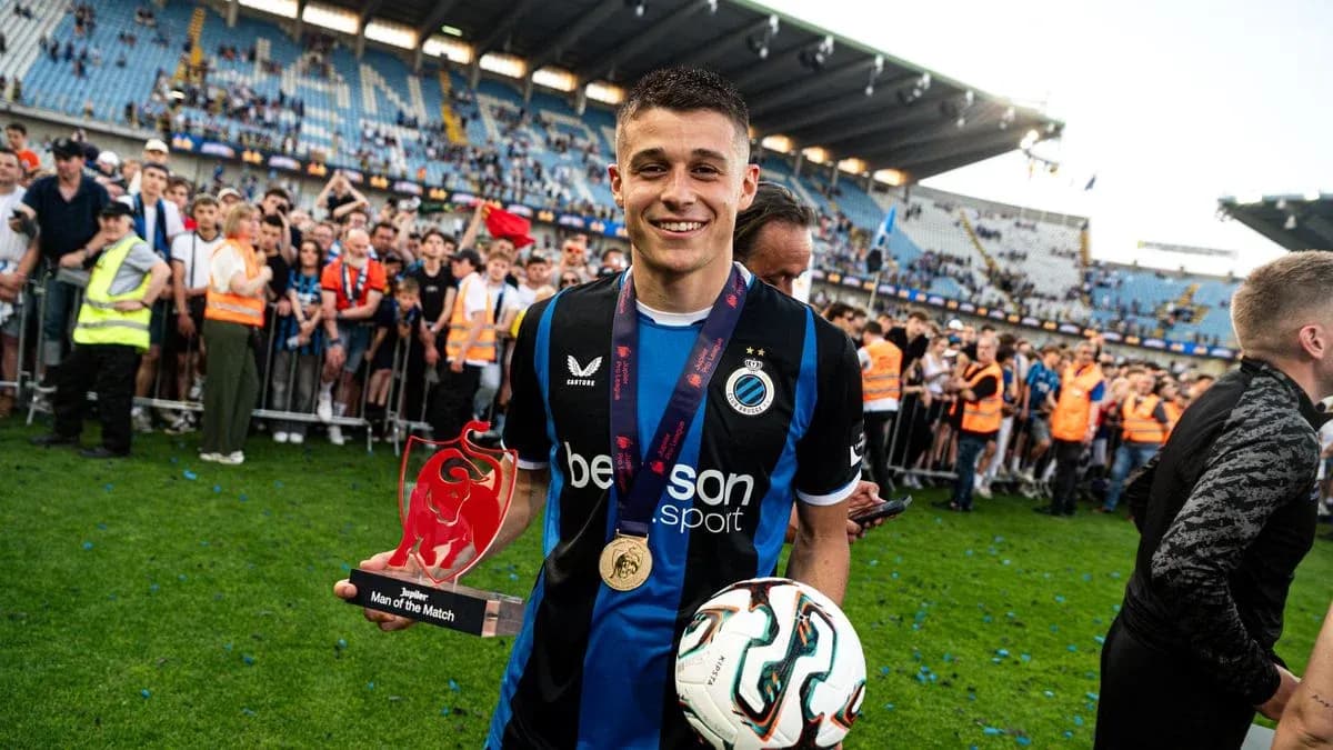 Jugador sosteniendo trofeo y balón en celebración Jugador sosteniendo trofeo y balón en celebración