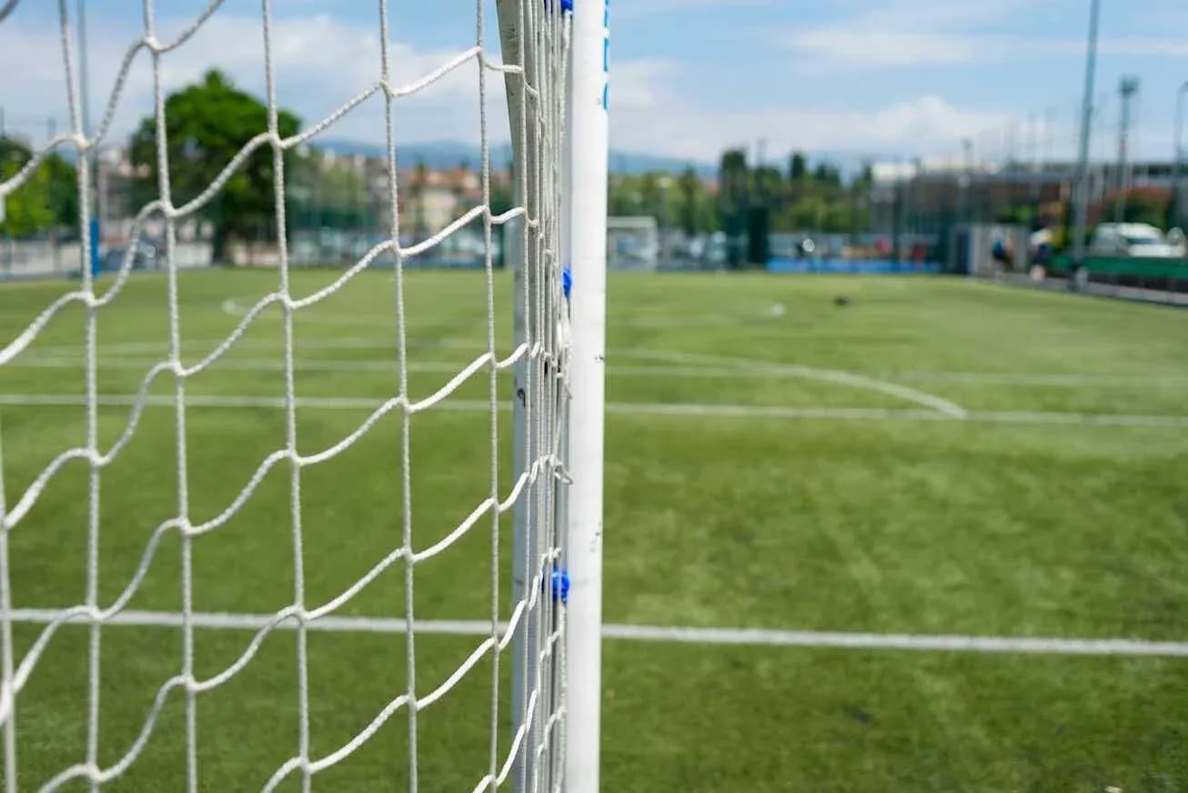 Red de un arco de fútbol en campo verde Red de un arco de fútbol en campo verde