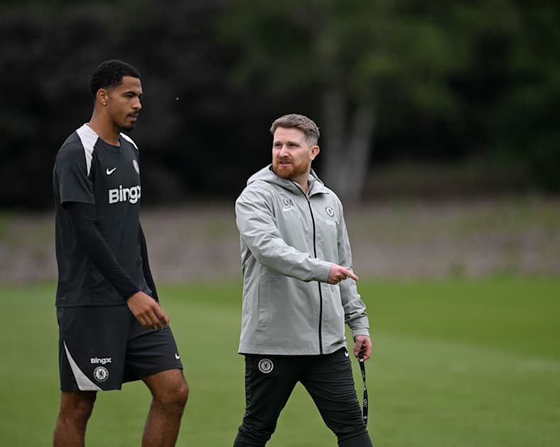 Jugador y entrenador conversando en el campo de entrenamiento Jugador y entrenador conversando en el campo de entrenamiento