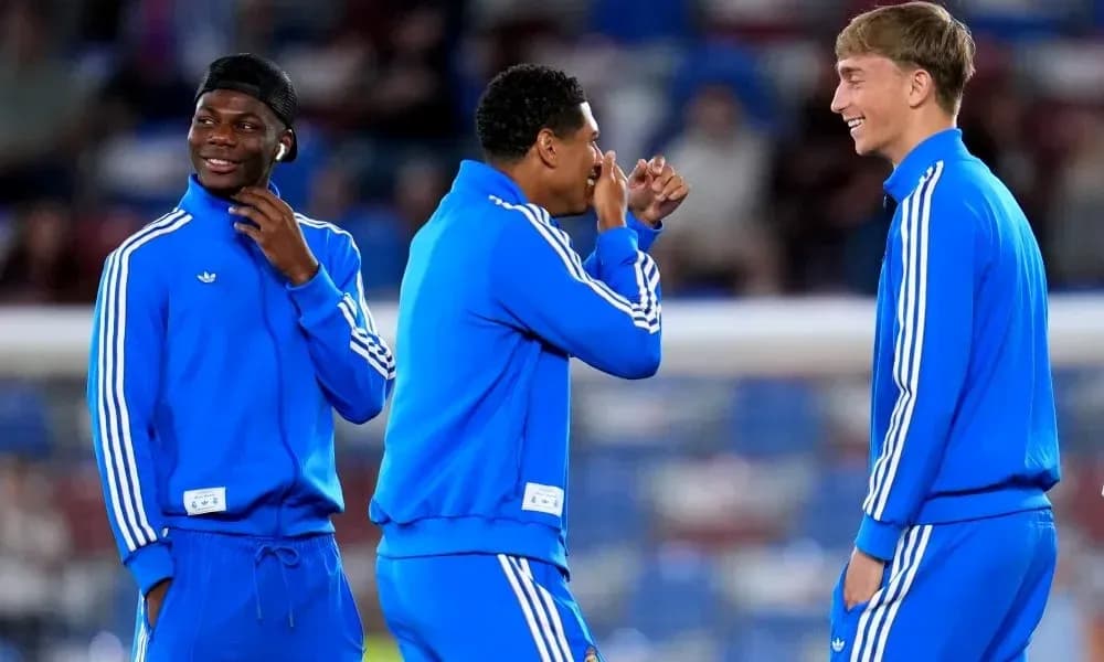 Tres jugadores en ropa de entrenamiento sonriendo juntos Tres jugadores en ropa de entrenamiento sonriendo juntos