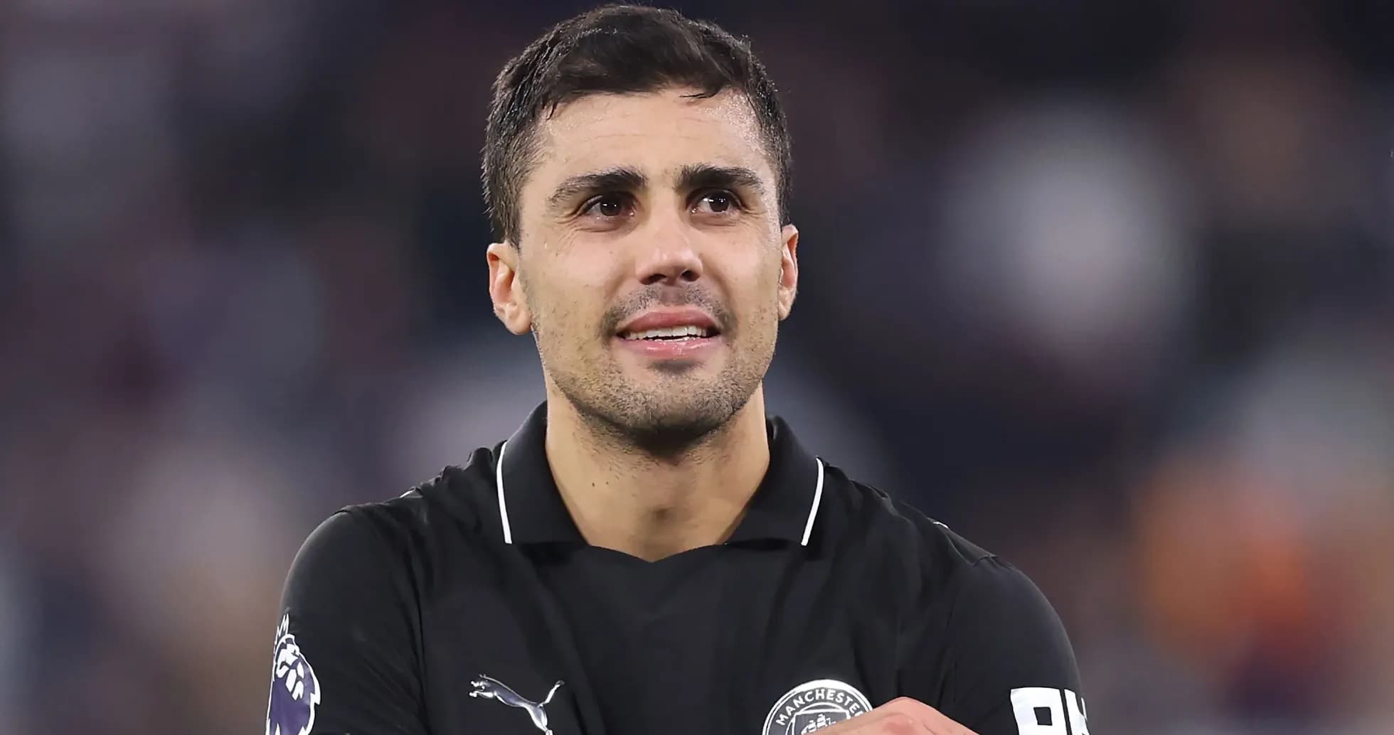 Jugador de fútbol en uniforme negro sonriendo Jugador de fútbol en uniforme negro sonriendo