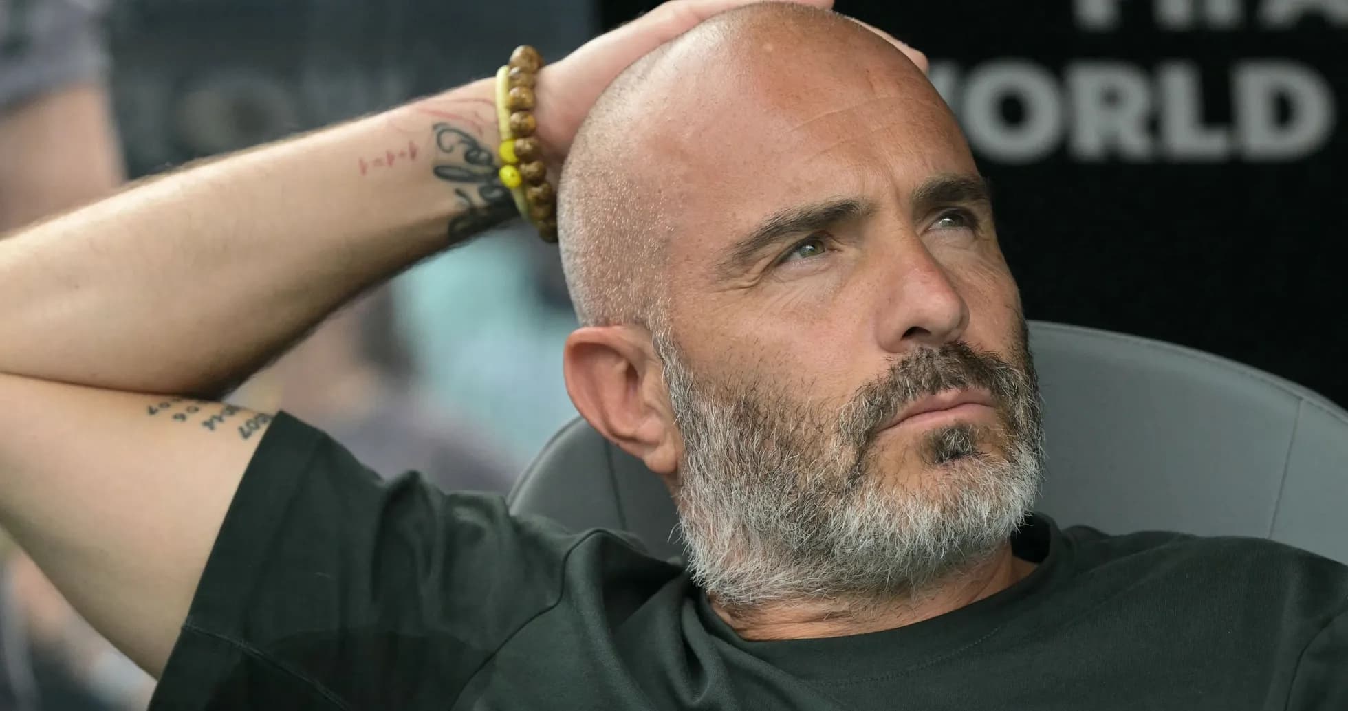 Entrenador sentado con mano en la cabeza Entrenador sentado con mano en la cabeza