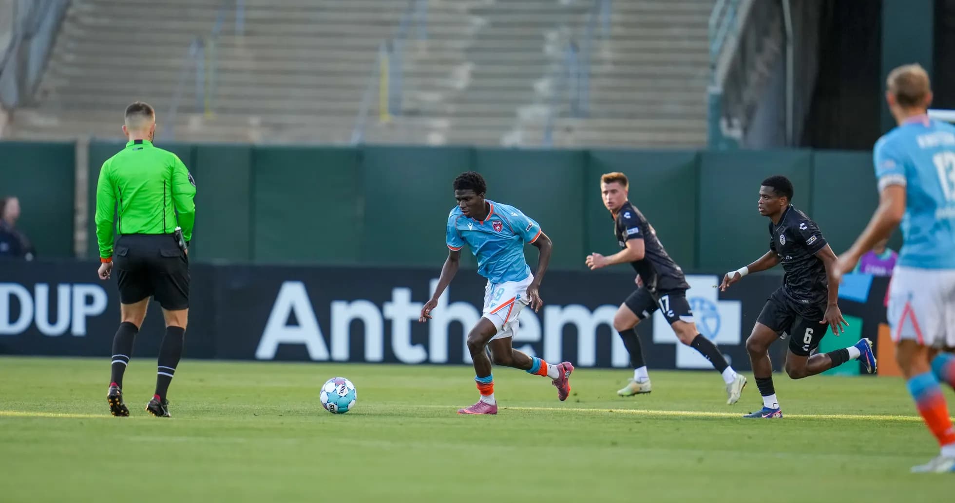 Jugador de Miami FC con balón en el campo Jugador de Miami FC con balón en el campo